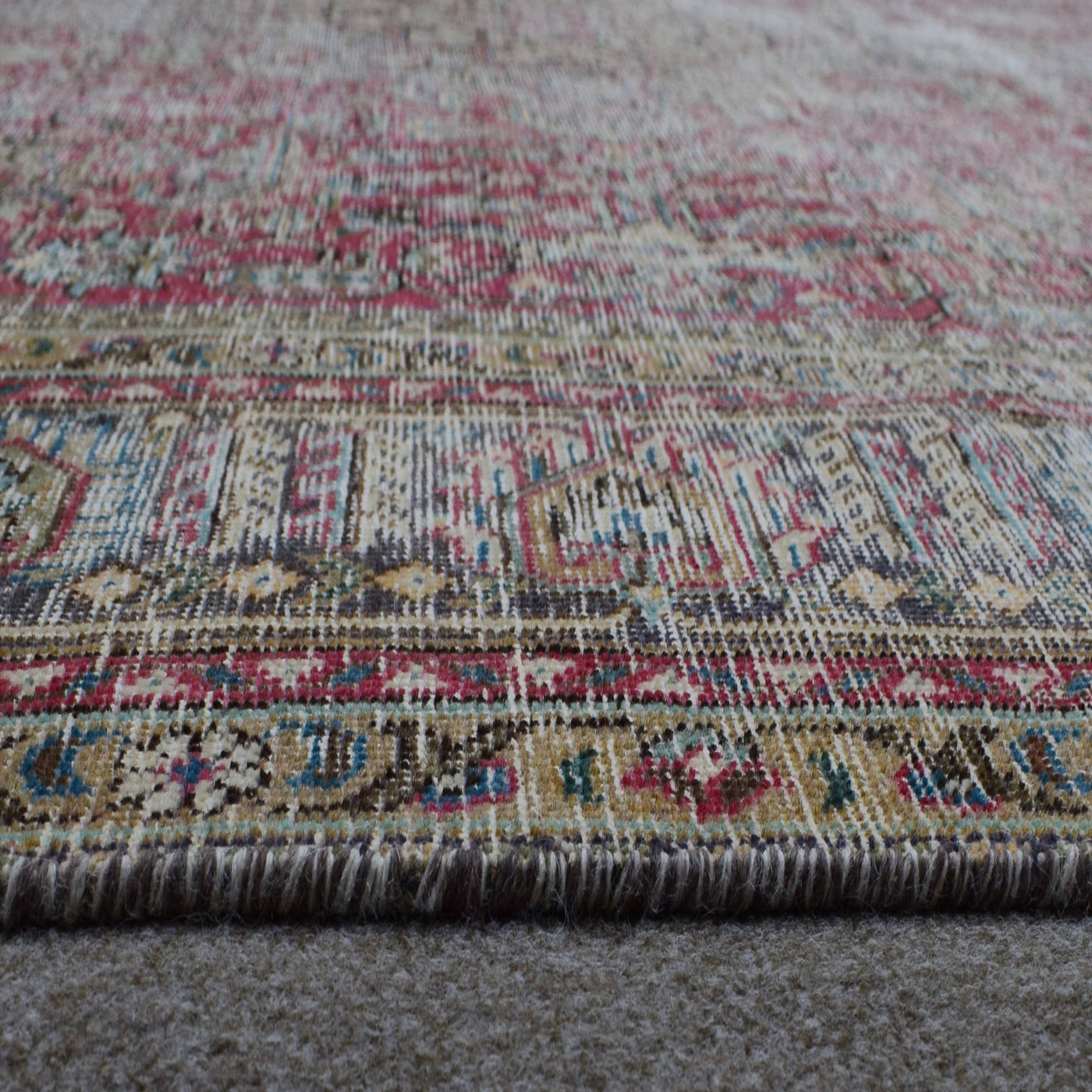 Macro detail of Persian rug pattern highlighting worn wool texture and faded design