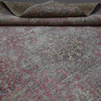 Detailed view of distressed Persian rug floral pattern with soft rose tones