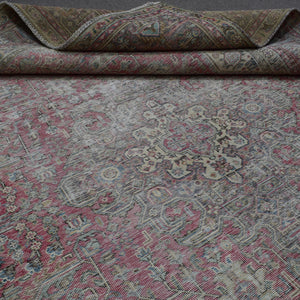 Detailed view of distressed Persian rug floral pattern with soft rose tones