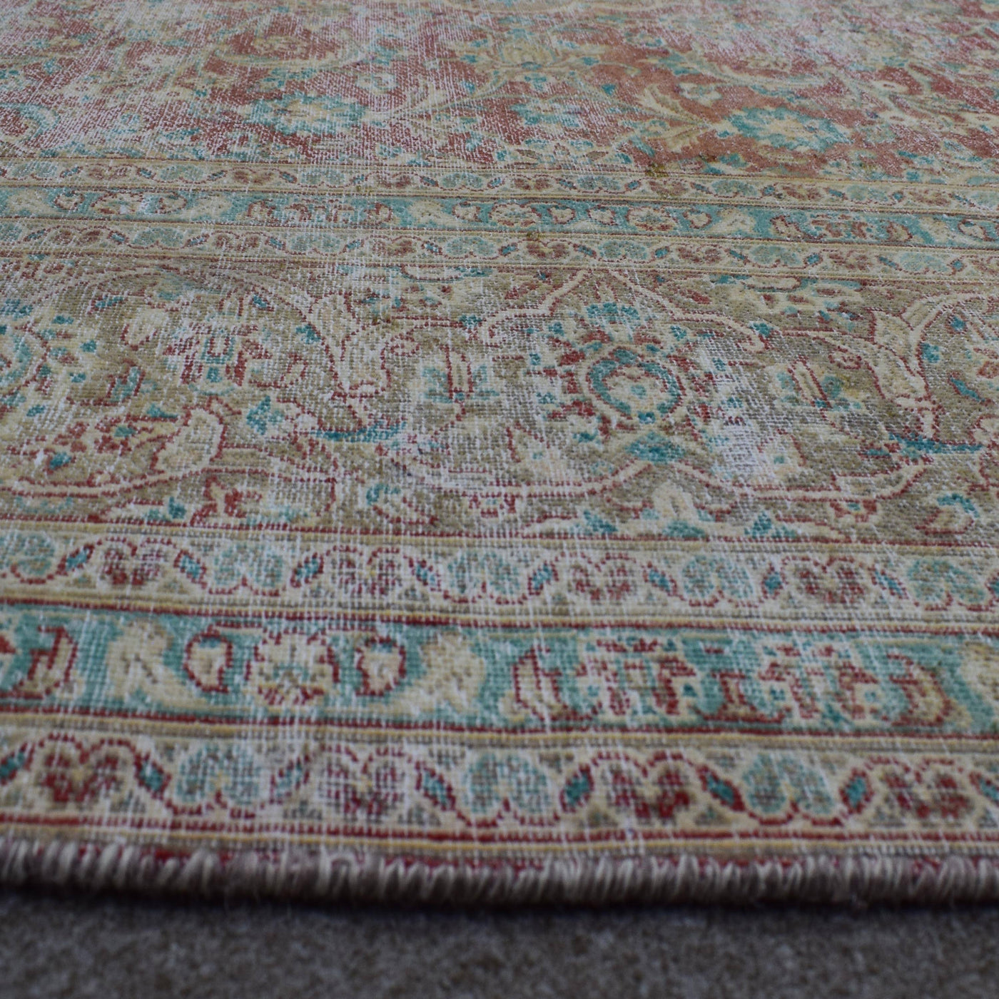 Macro detail of Persian rug medallion highlighting worn wool texture and faded design