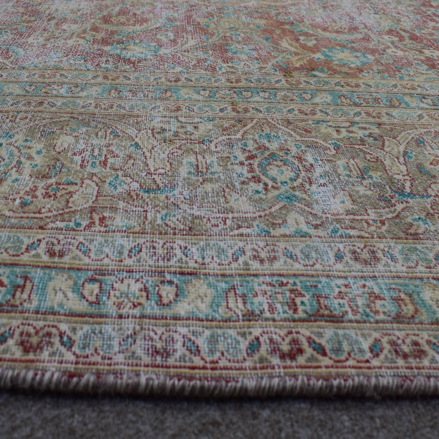 Macro detail of Persian rug medallion highlighting worn wool texture and faded design