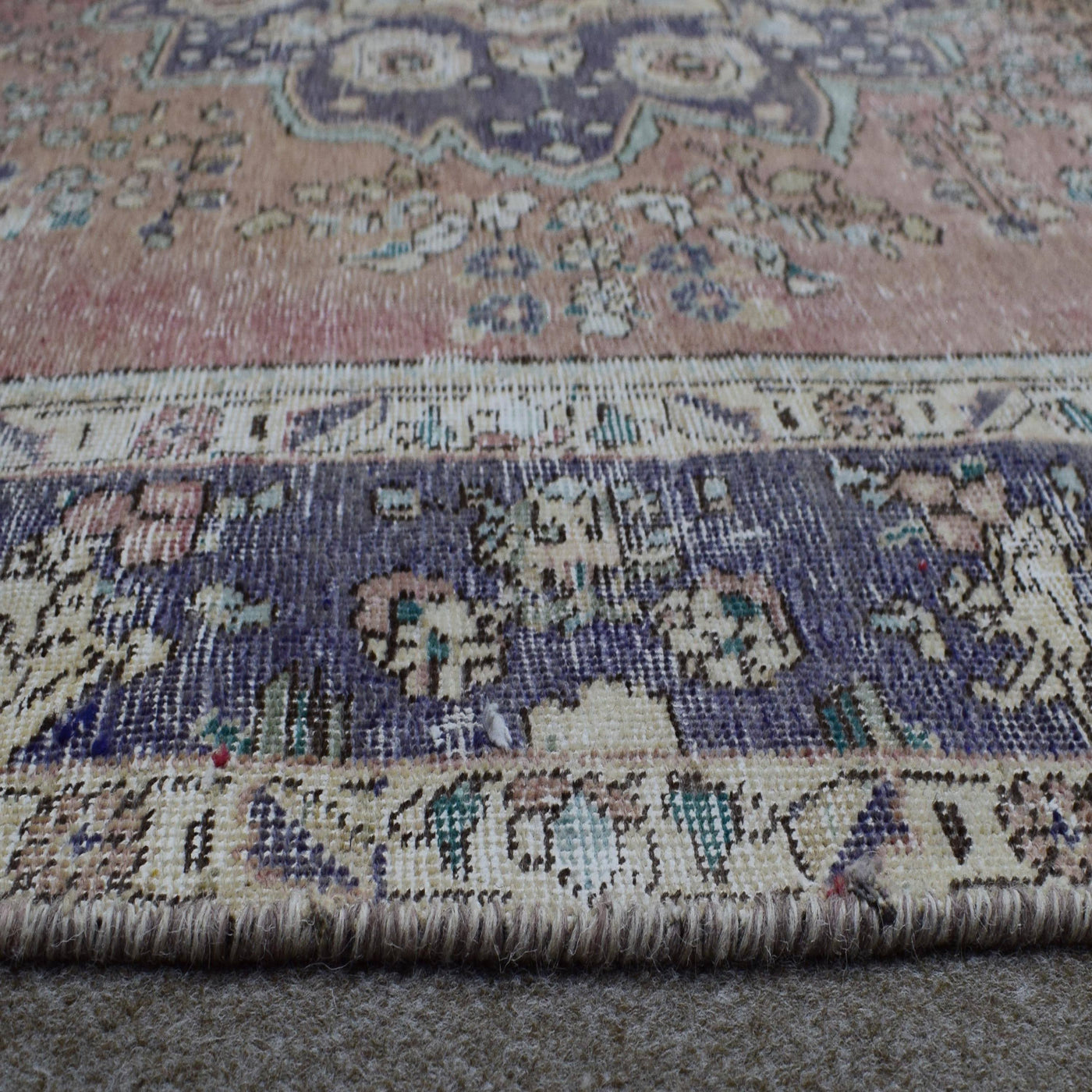 Close up of Persian rug border with deep blue floral motifs and intricate guard stripes
