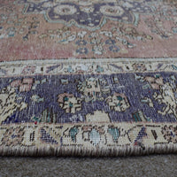 Close up of Persian rug border with deep blue floral motifs and intricate guard stripes