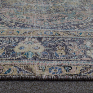 Macro detail of Persian rug medallion highlighting worn wool texture and faded pattern