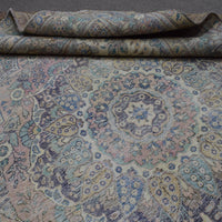 Detailed view of distressed Persian rug pattern with soft ivory tones and ornamental motifs