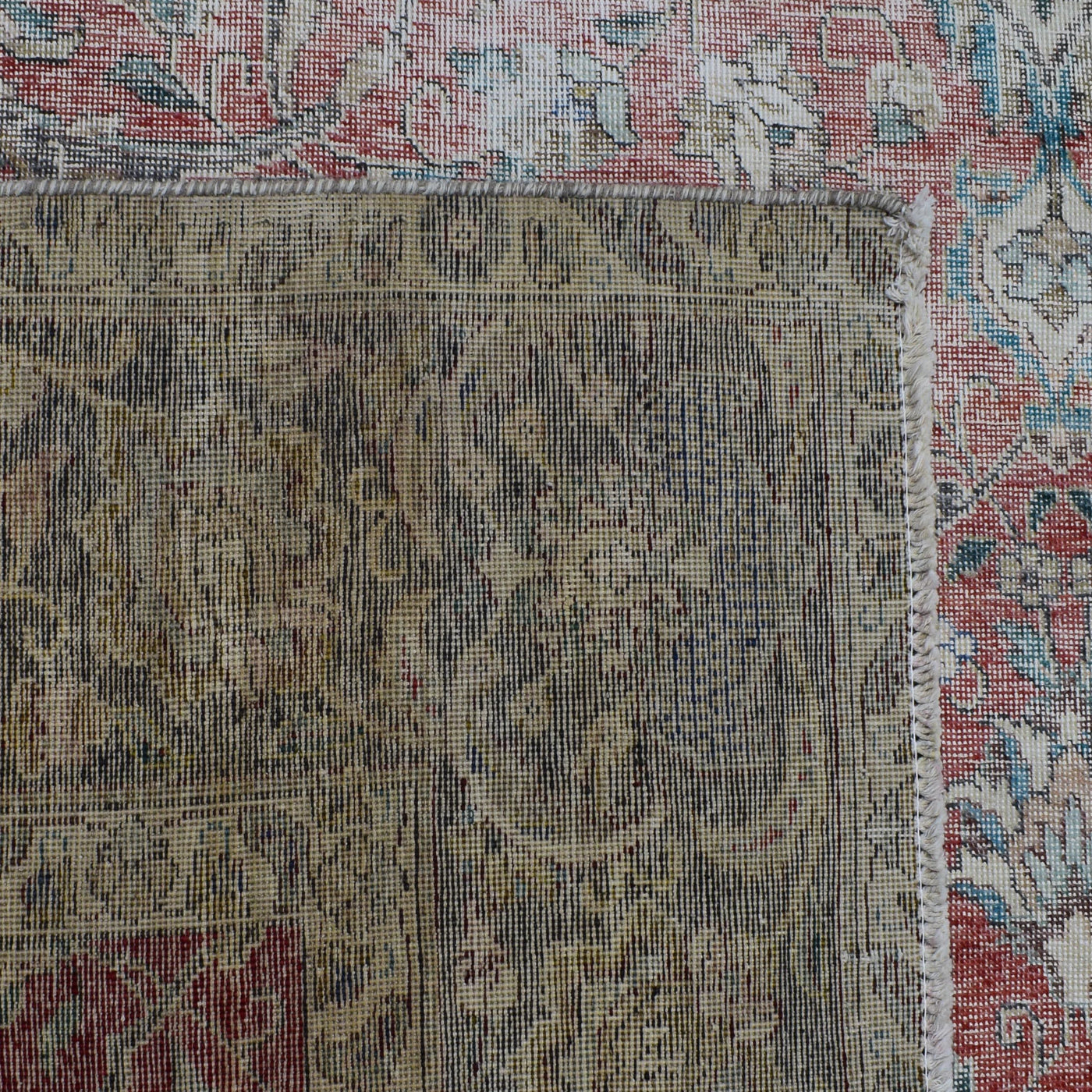 Macro detail of Persian rug pattern highlighting worn wool texture and faded design