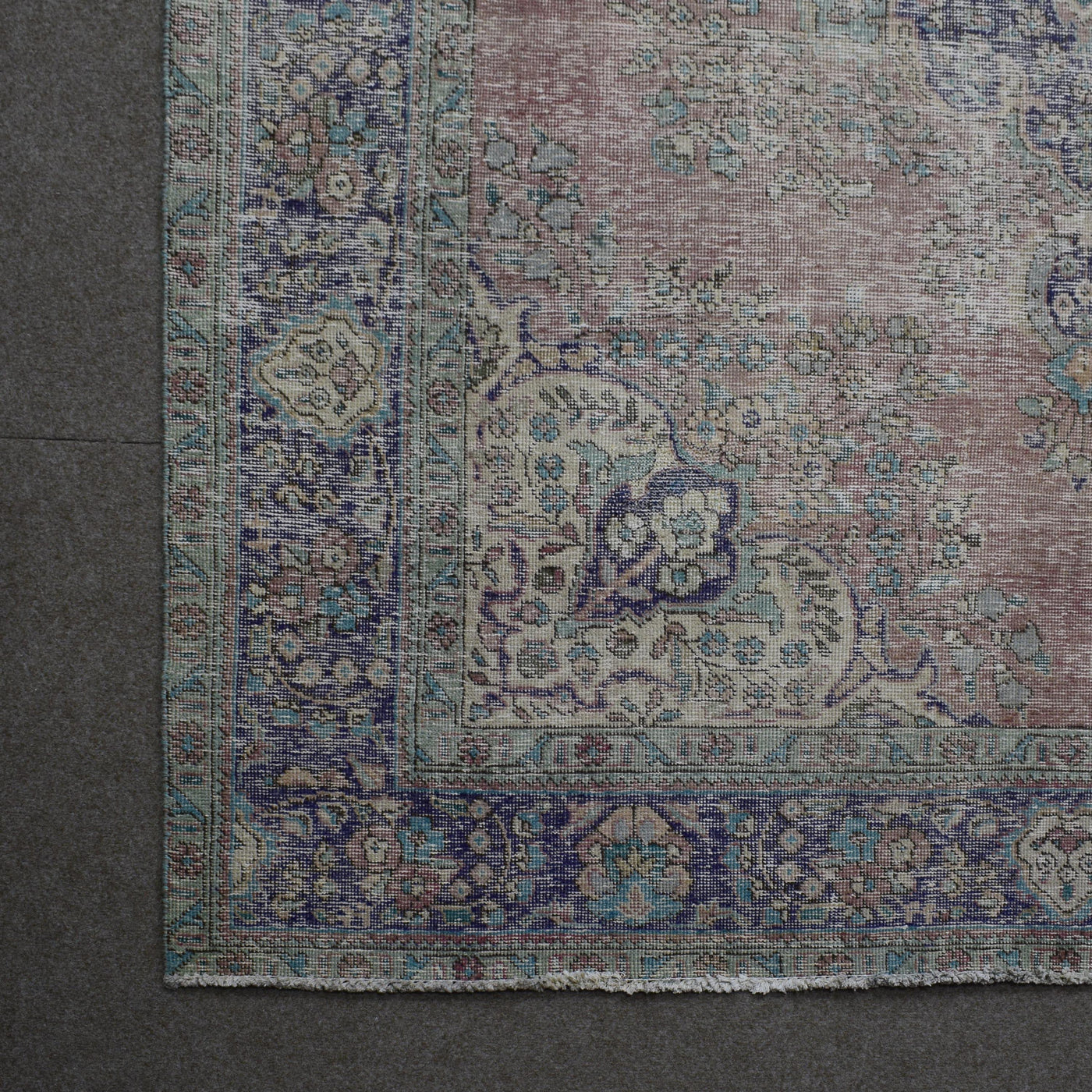 Corner detail of vintage Persian rug showing decorative border and classic Persian motifs