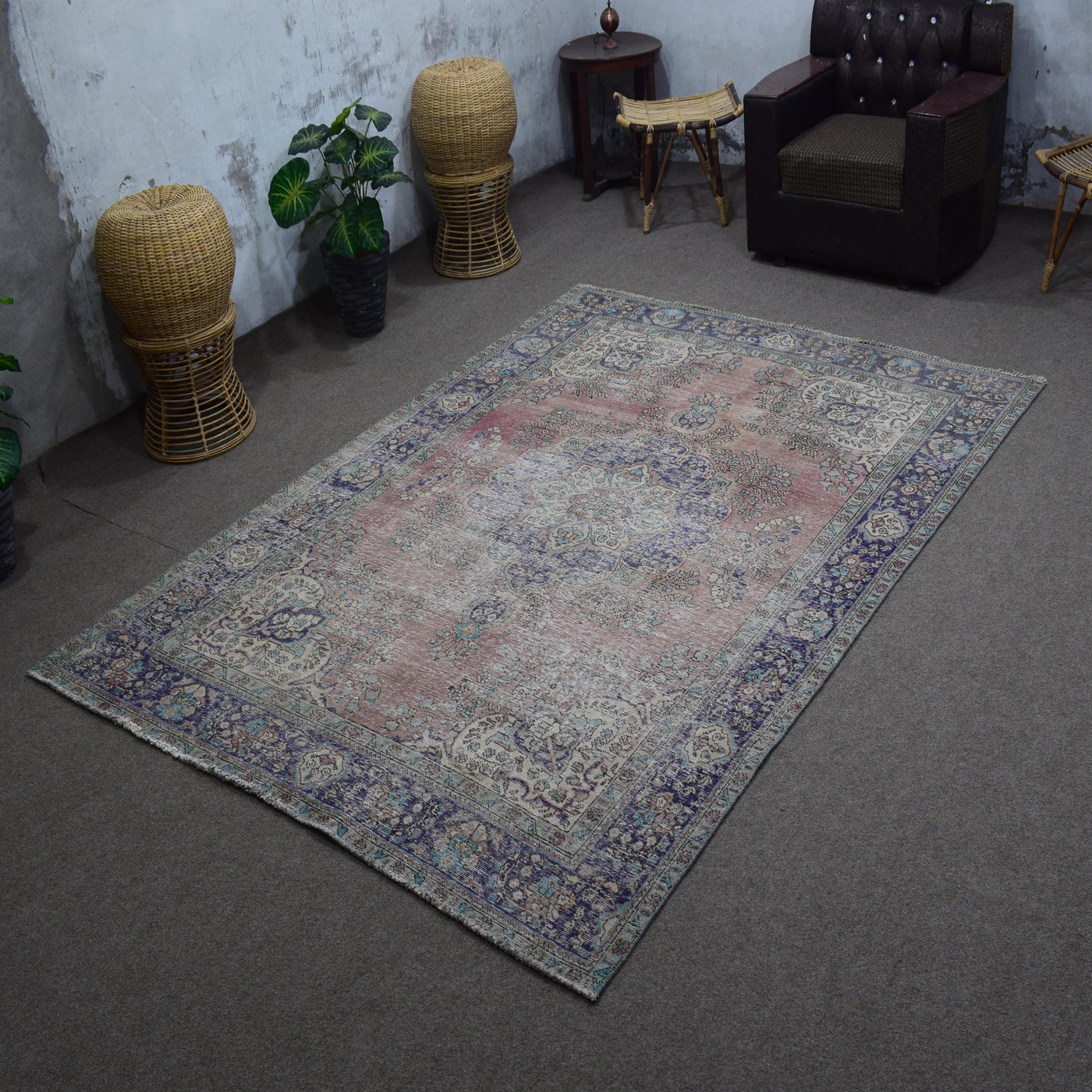 Angled view of hand knotted Persian rug highlighting full layout and worn vintage character