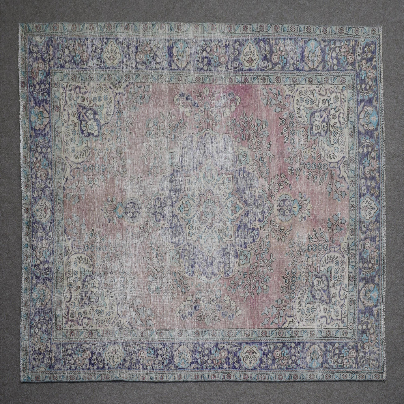 Close up of Persian rug border featuring blue floral pattern and intricate guard stripes
