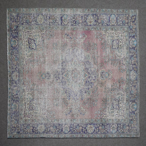 Close up of Persian rug border featuring blue floral pattern and intricate guard stripes