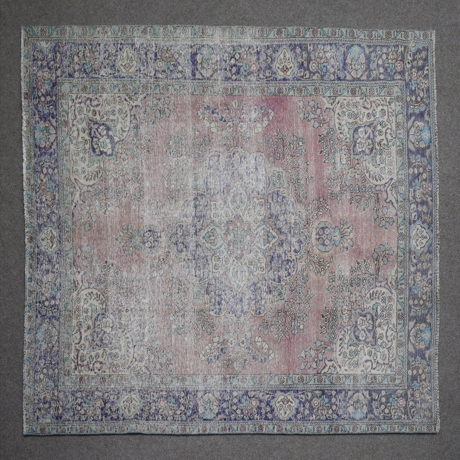 Close up of Persian rug border featuring blue floral pattern and intricate guard stripes