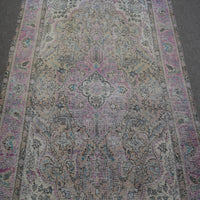 Close up of Persian rug medallion with faded pink and blue floral motifs