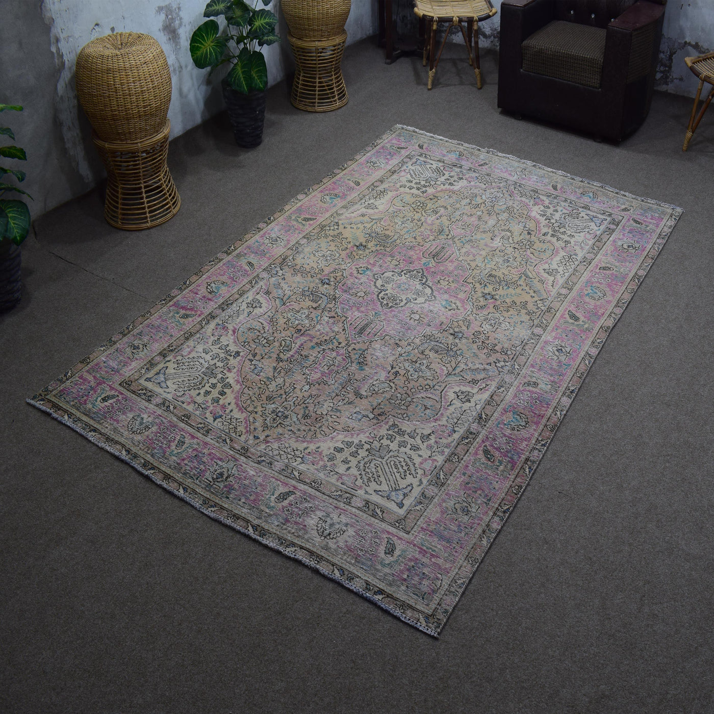 Angled view of hand knotted Persian rug highlighting overall layout and worn vintage character