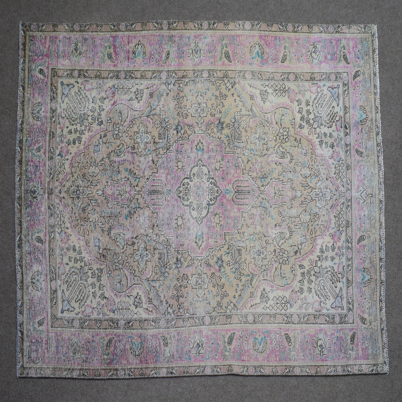 Close up of Persian rug border with pink and blue floral motifs and classic Persian pattern
