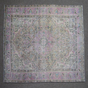 Close up of Persian rug border with pink and blue floral motifs and classic Persian pattern