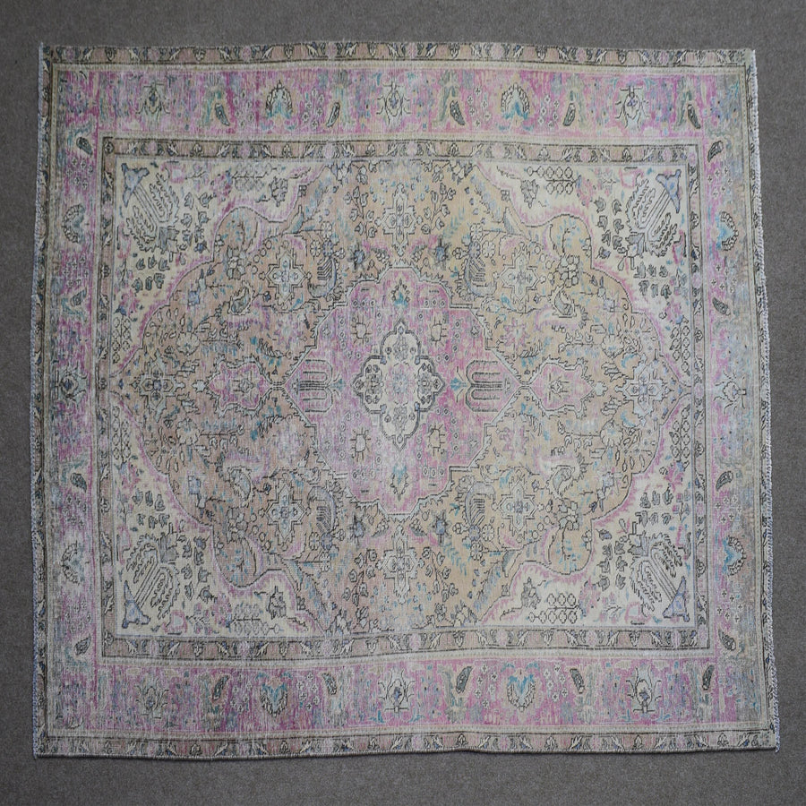 Close up of Persian rug border with pink and blue floral motifs and classic Persian pattern