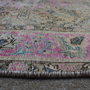 Macro detail of distressed Persian rug weave showing worn wool texture and faded dyes