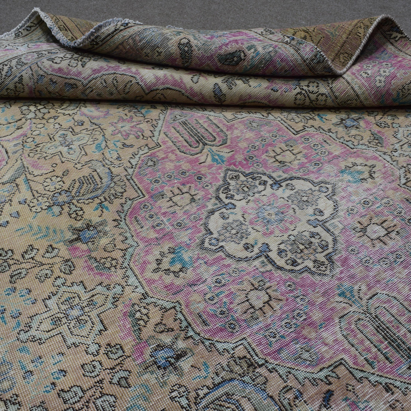 Close up of Persian rug medallion motif with antique pastel palette and intricate details