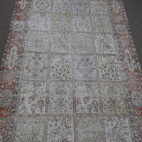 Close up of Persian patchwork rug panels featuring floral motifs in soft neutral tones