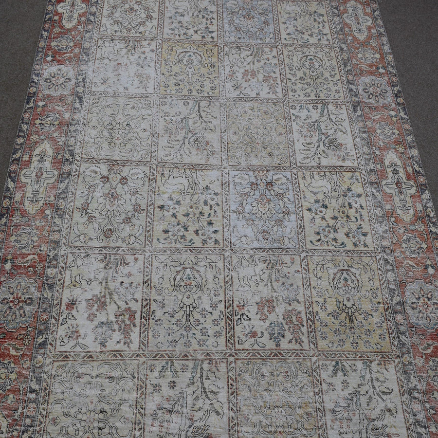 Close up of Persian patchwork rug panels featuring floral motifs in soft neutral tones