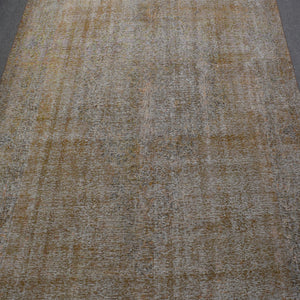 Overdyed Persian rug with distressed antique look and soft beige tonal variations
