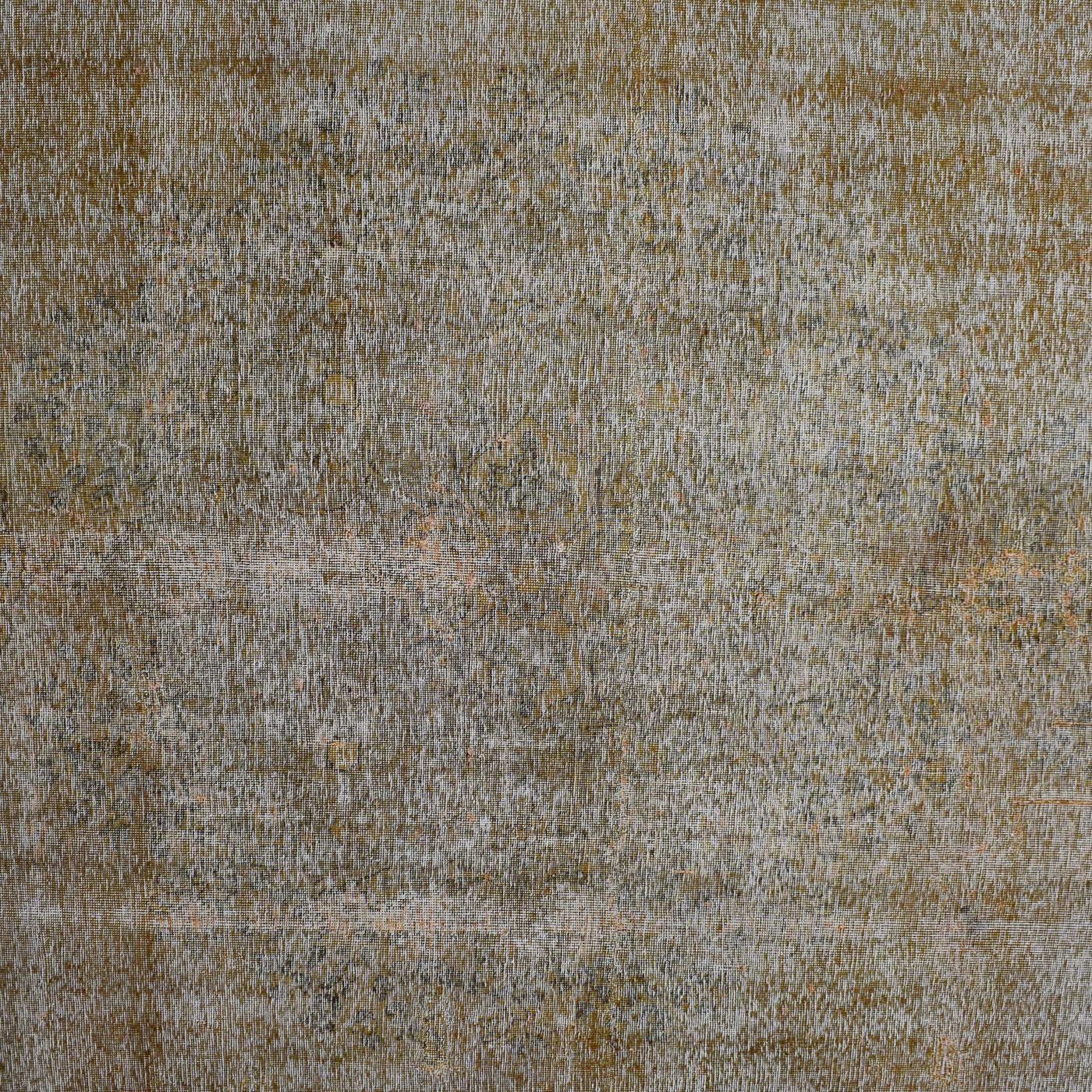 Close-up of overdyed vintage Persian rug showing textured wool pile and muted neutral tones
