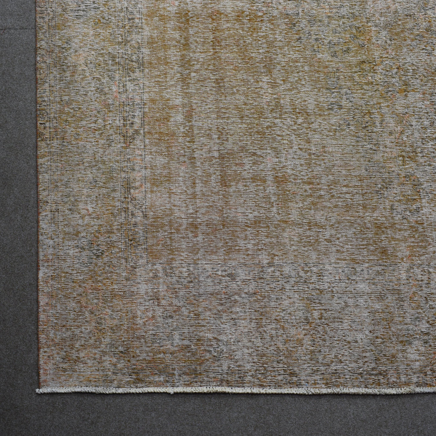 Detailed surface view of beige overdyed Persian rug highlighting worn vintage patina
