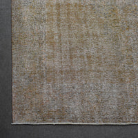 Detailed surface view of beige overdyed Persian rug highlighting worn vintage patina
