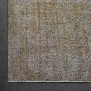Detailed surface view of beige overdyed Persian rug highlighting worn vintage patina
