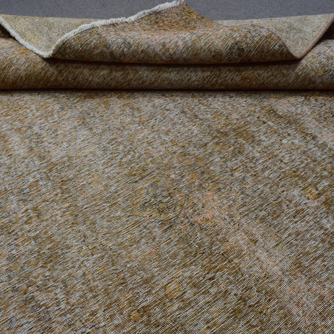 Macro detail of overdyed Persian rug showing dense hand knotted weave structure
