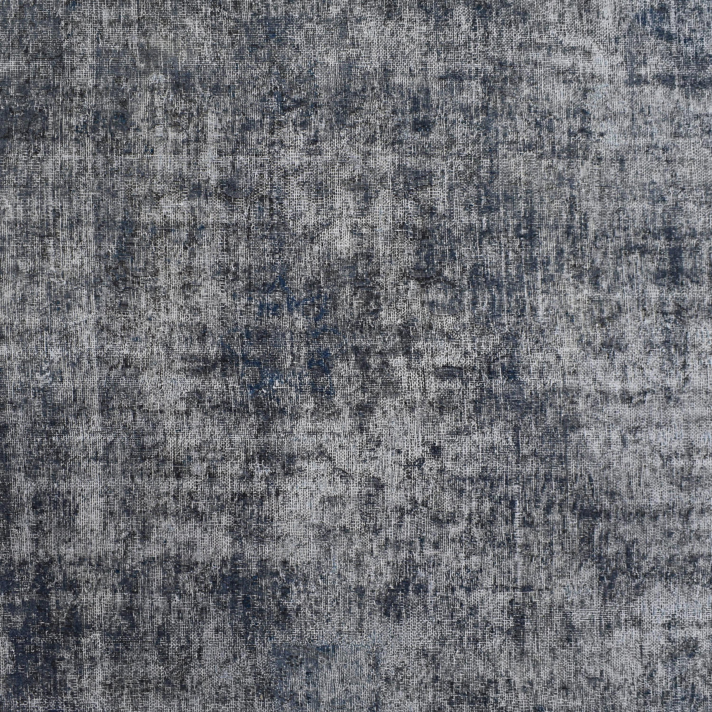 Close-up of overdyed vintage Persian rug showing textured wool pile and mottled grey blue tones
