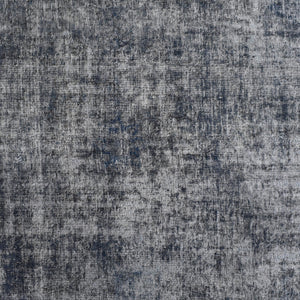 Close-up of overdyed vintage Persian rug showing textured wool pile and mottled grey blue tones
