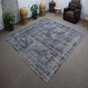 Angled view of large overdyed rug emphasizing subtle shading and modern minimalist character
