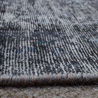 Macro detail of overdyed Persian rug showing dense hand knotted weave structure
