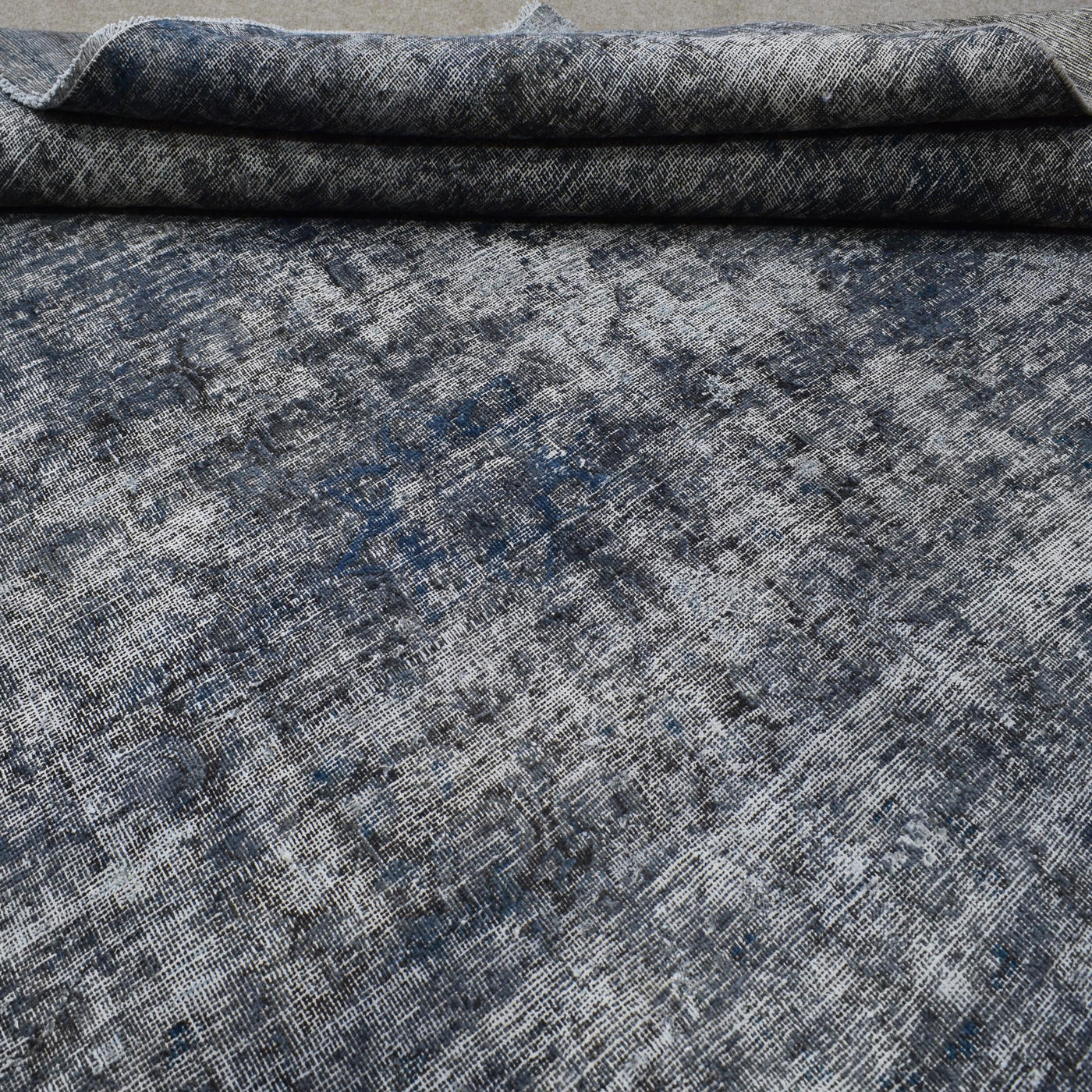 Edge detail of hand knotted overdyed Persian rug with visible binding and tonal depth

