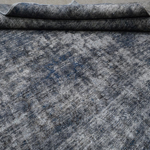 Edge detail of hand knotted overdyed Persian rug with visible binding and tonal depth
