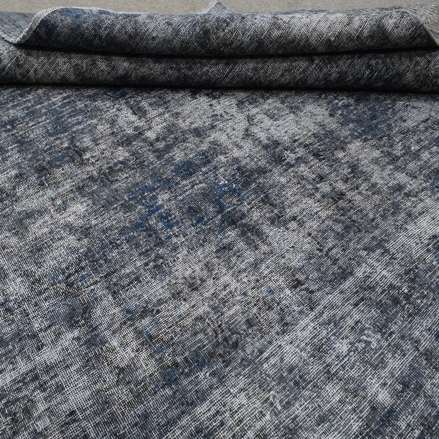 Edge detail of hand knotted overdyed Persian rug with visible binding and tonal depth
