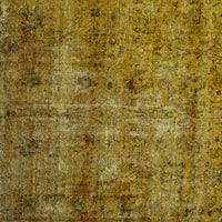 Close-up of overdyed vintage Persian rug showing textured wool pile and mottled gold tones
