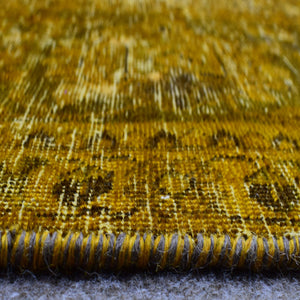 Macro detail of overdyed Persian rug showing dense hand knotted weave structure
