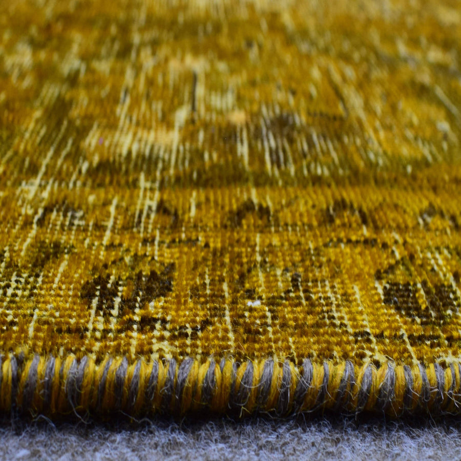 Macro detail of overdyed Persian rug showing dense hand knotted weave structure

