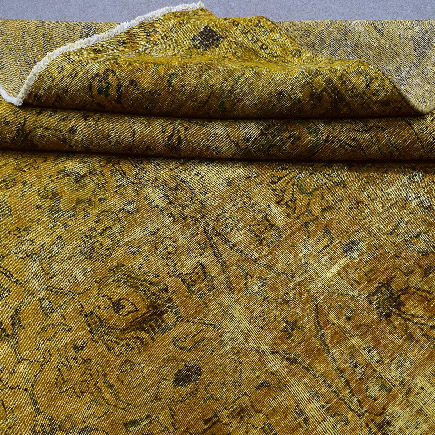 Edge detail of hand knotted overdyed Persian rug with visible binding and tonal shading
